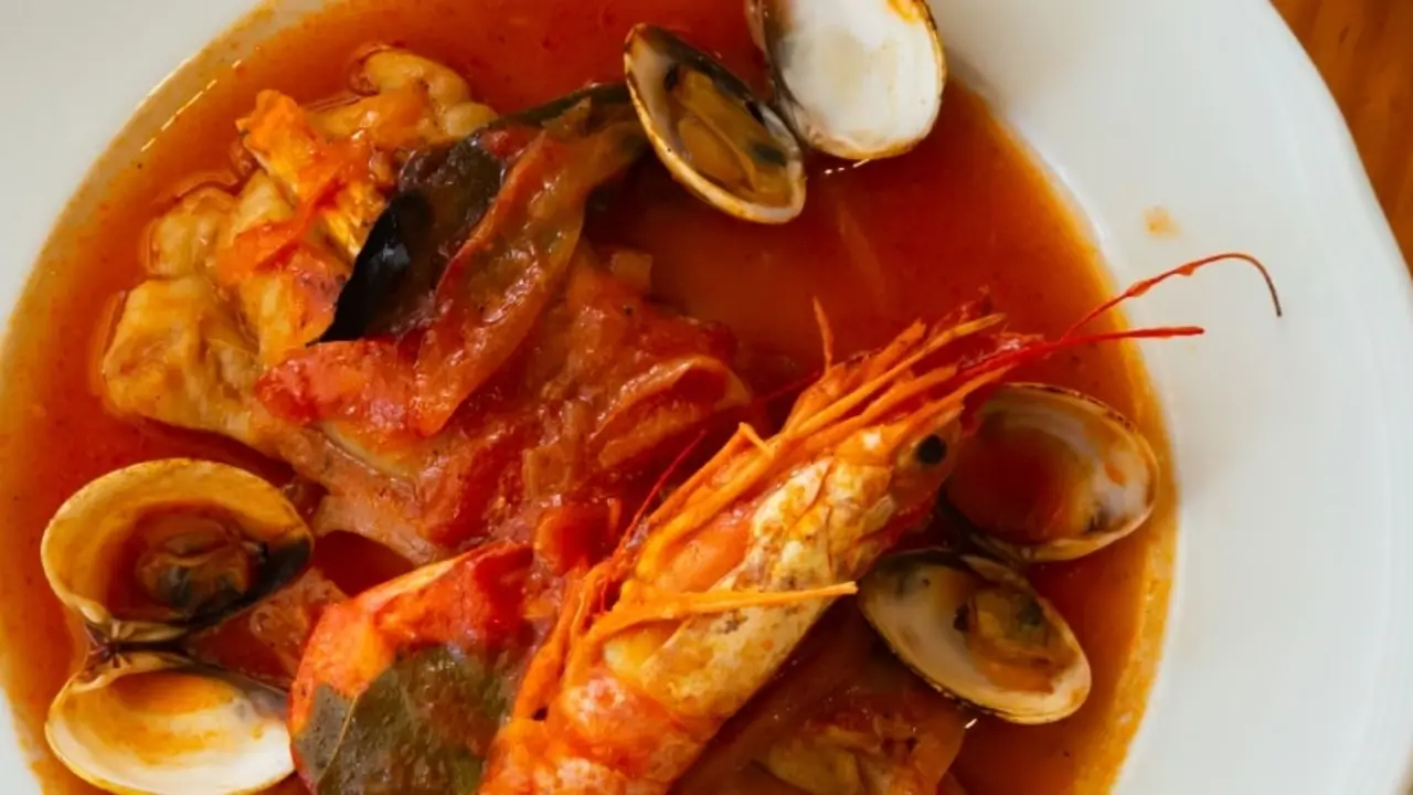 Plato de medallones de rape en salsa con almejas y langostinos. | Shutterstock