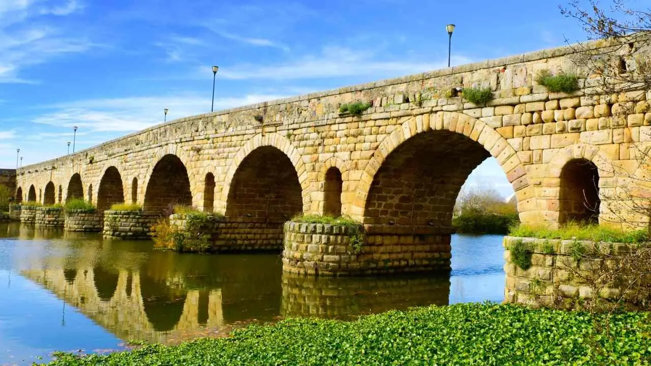 a view of the Puente Romano, an ancient Roman bridge over the Guadiana River, in Merida, Spain