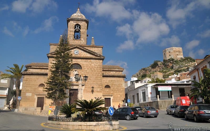 Fachada Iglesia de Vélez de Benaudalla, con el castillo de los Ulloa al fondo