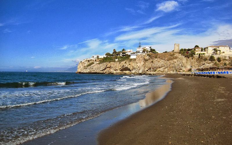 Playa con la torre del Cantal de fondo en Rincón de la Victoria