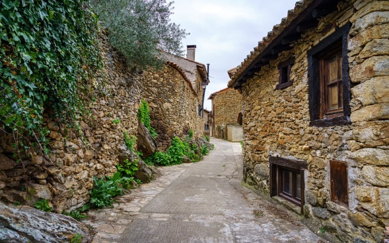 Calle estrecha llena de arquitectura tradicional en Horcajuelo de la Sierra