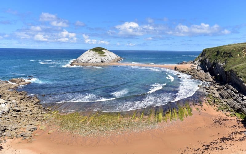 La playa Covachos en bajamar unida a la isla de Castro