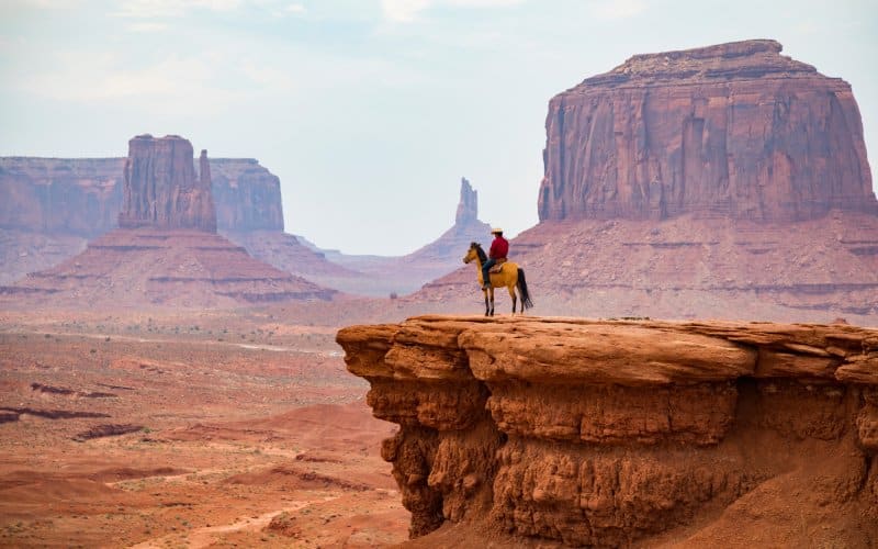 Una vaquero a lomos de un caballo en el Parque Tribal Navajo del Valle del Monumento