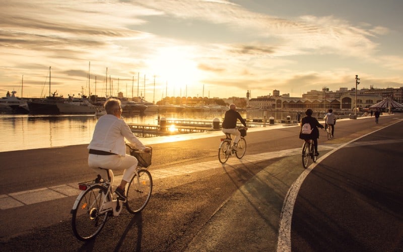 Varias personas recorren el puerto de Valencia en bicicleta