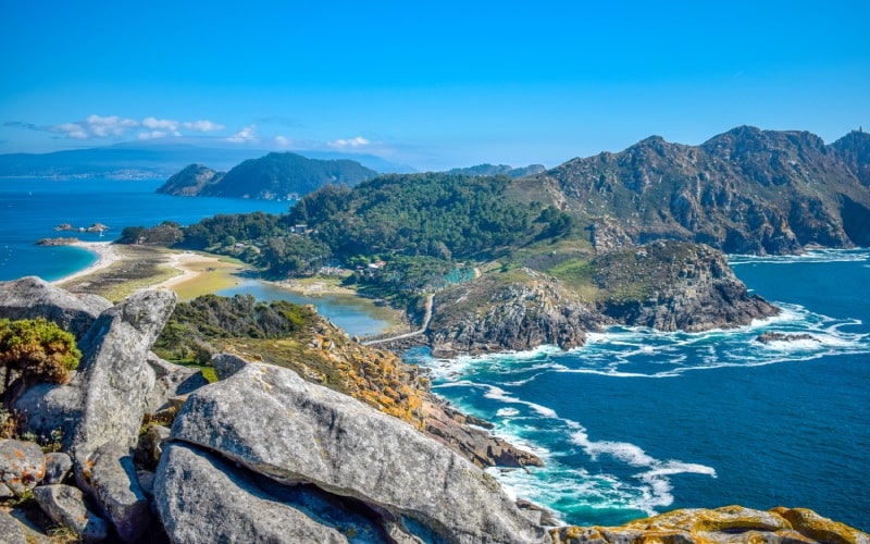 Una vista panorámica que abarca verdes colinas, playas y acantilados