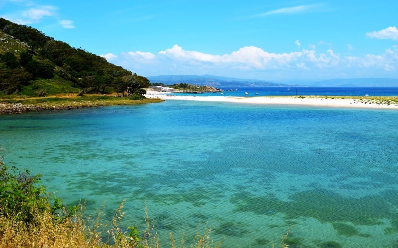 Una laguna de aguas turquesas, con la playa y el mar de fondo