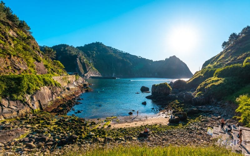 Una playa de piedras entre colinas verdes