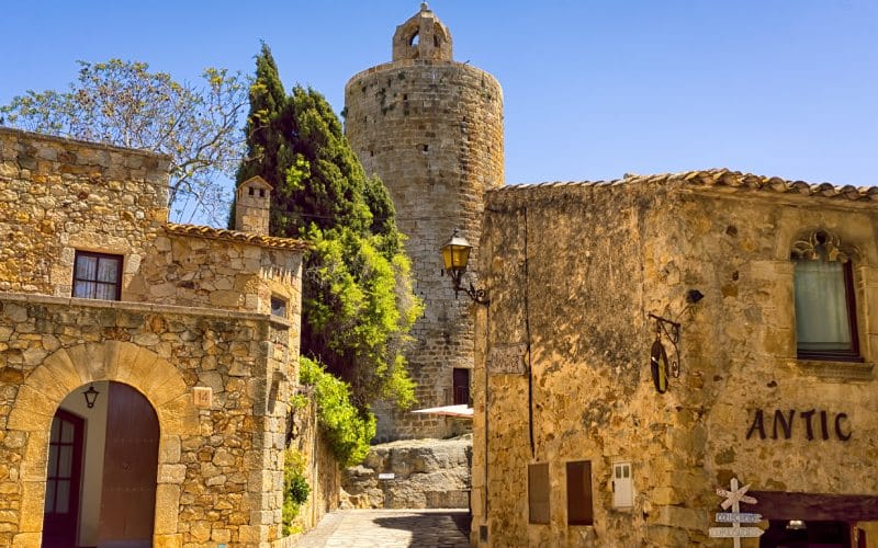 Casas de piedra y una torre en lo alto de la calle