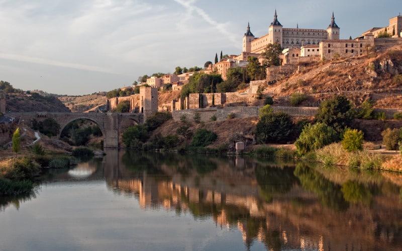 Una ciudad de edificios antiguos sobre un río con un puente