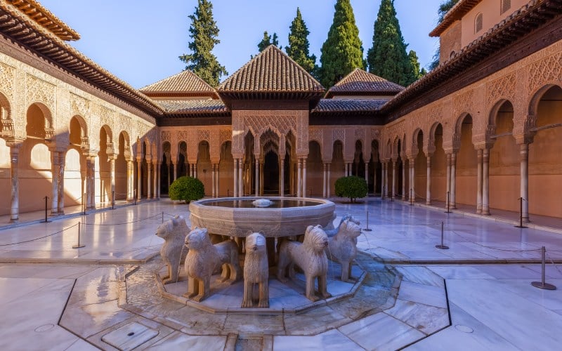 Un patio con una fuente de leones