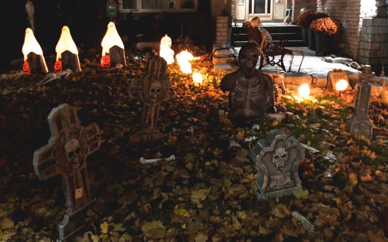 El jardín de una casa decorada con lápidas, calaveras y calabazas