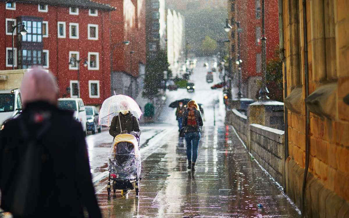 Gente caminando bajo la lluvia en una calle de Bilbao