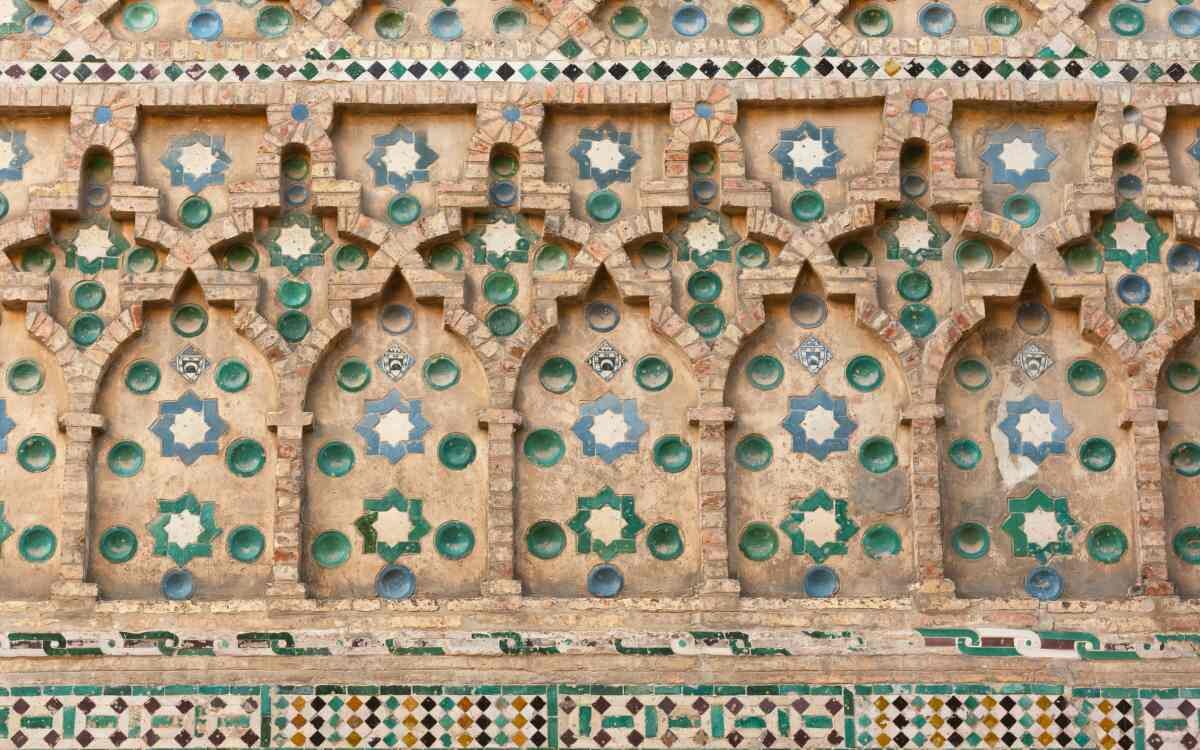 Primer plano detallado de arcos decorativos de estilo mudéjar con intrincados azulejos en la Catedral de La Seo en Zaragoza.