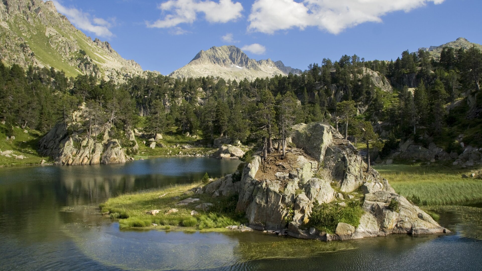 Lago rodeado de montañas en el Valle de Arán.
