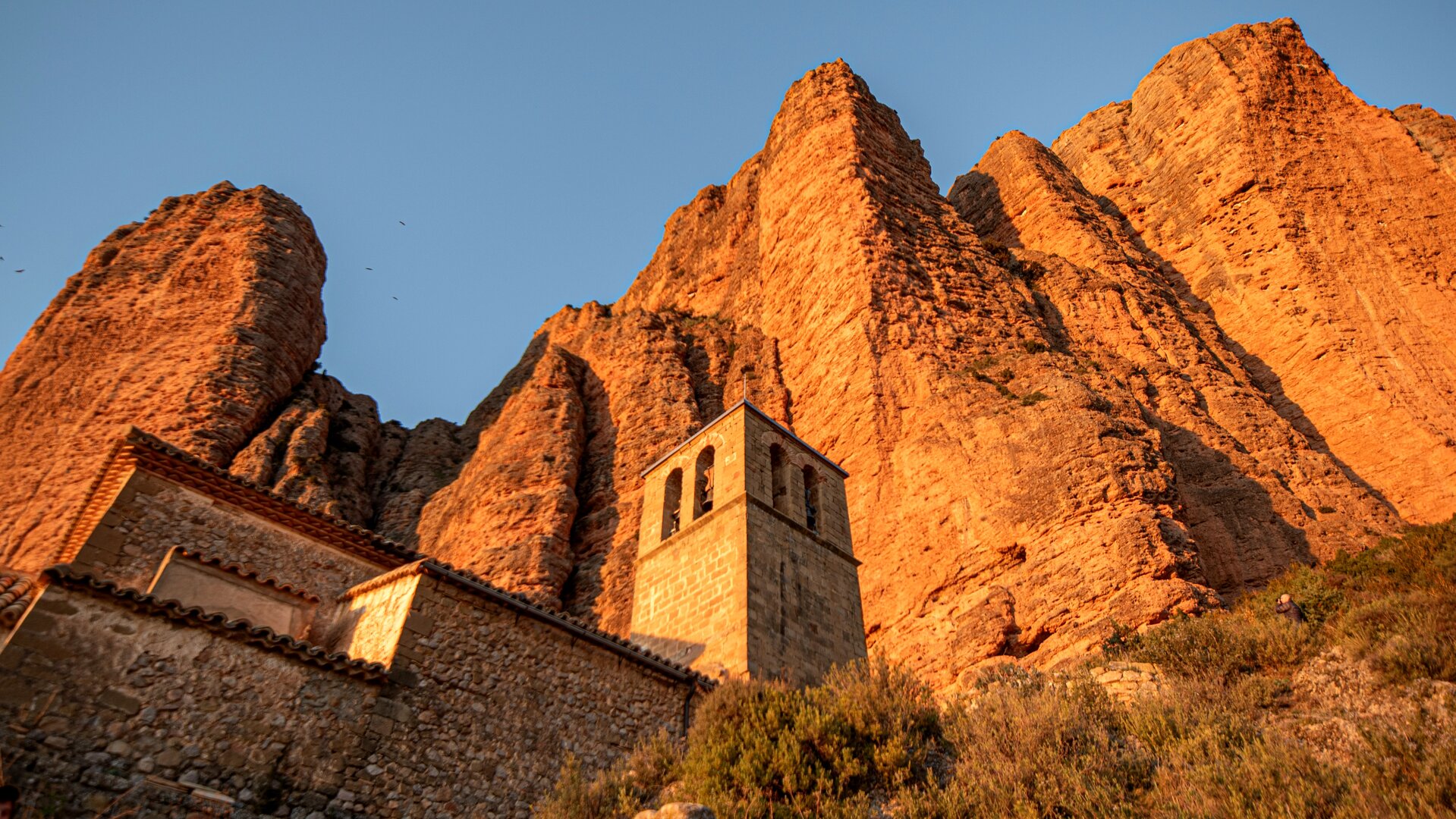 Iglesia de Riglos, bajo las imponentes formaciones rocosas.