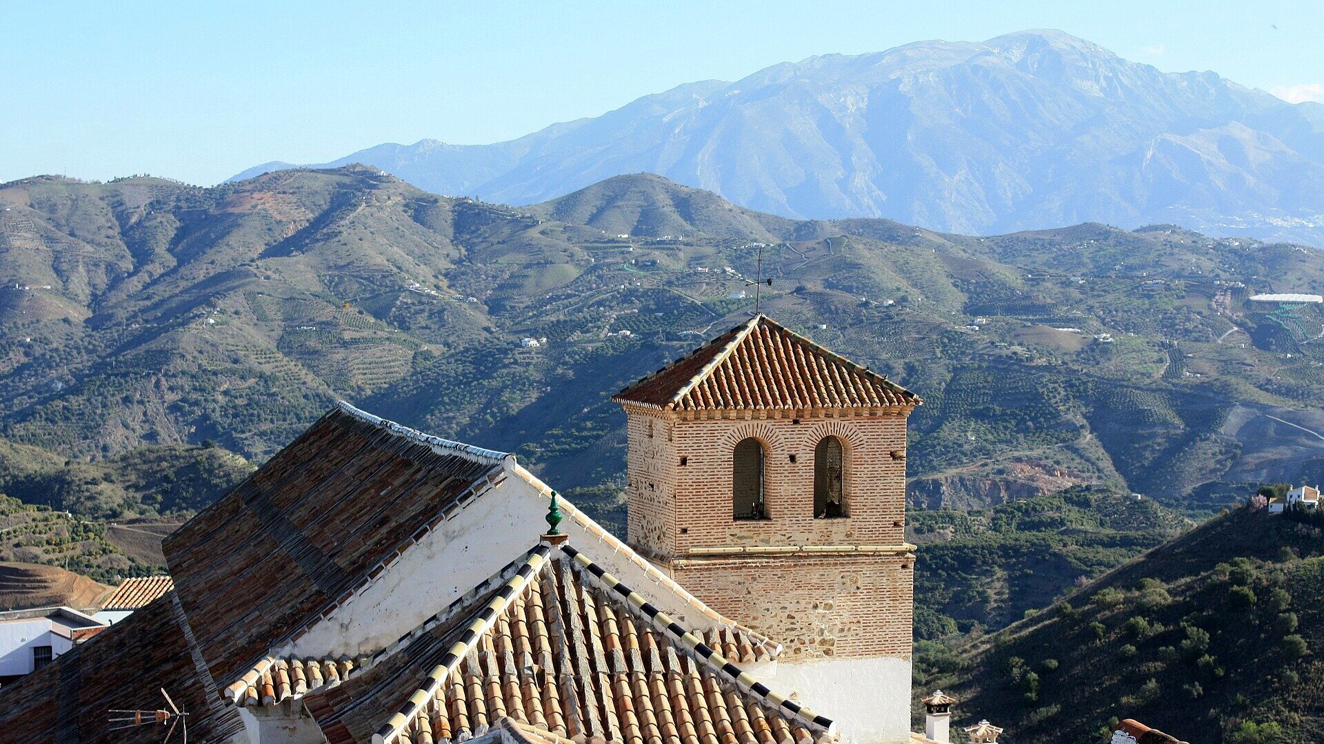 Campanario de la iglesia de Nuestra Señora de la Encarnación sobre las montañas.
