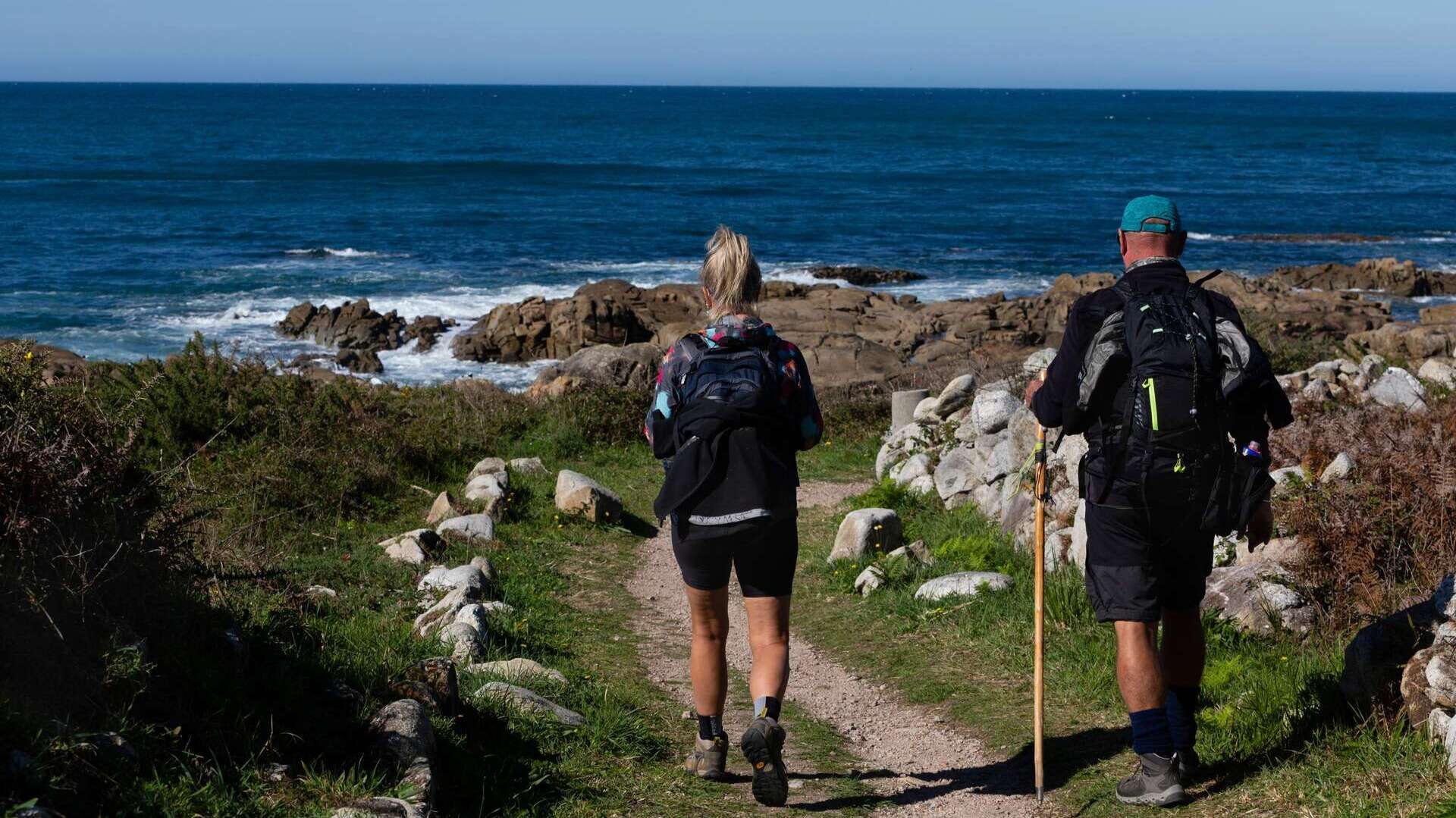 Dos peregrinos caminan por el camino portugués del Camino de Santiago. | Shutterstock