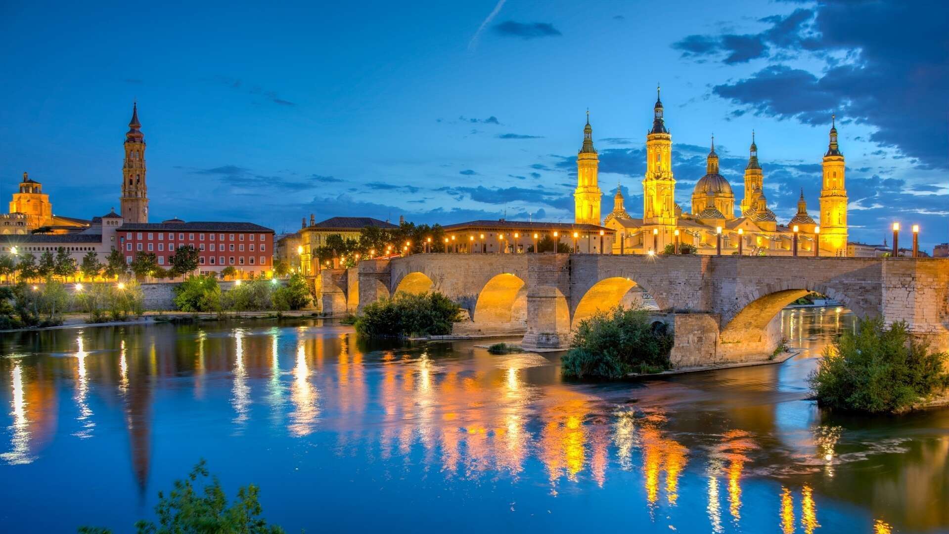 1 vida ncoturna de la basilica de nuestra señora del pilar, catedral del salvador y puente de piedra shutterstock_2402215835