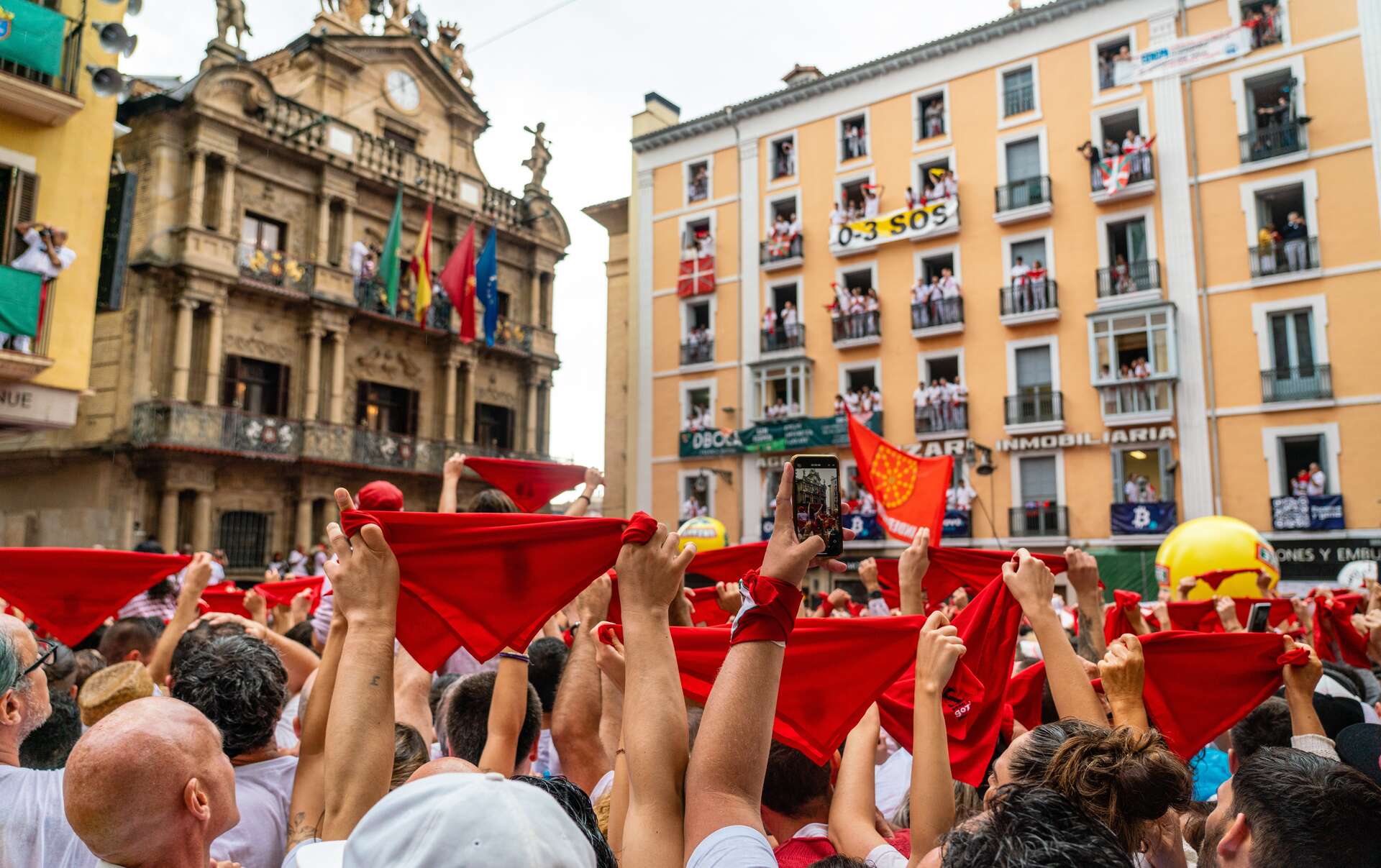 Pañuelos rojos en lo alto en la celebrción de San Fermín. | Shutterstock