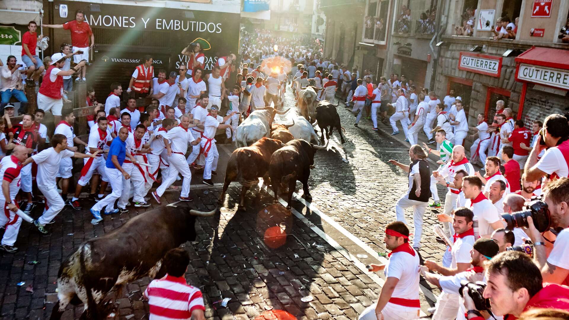 Gente corriendo junto a los toros en el encierro en San Fermín. | Shutterstock