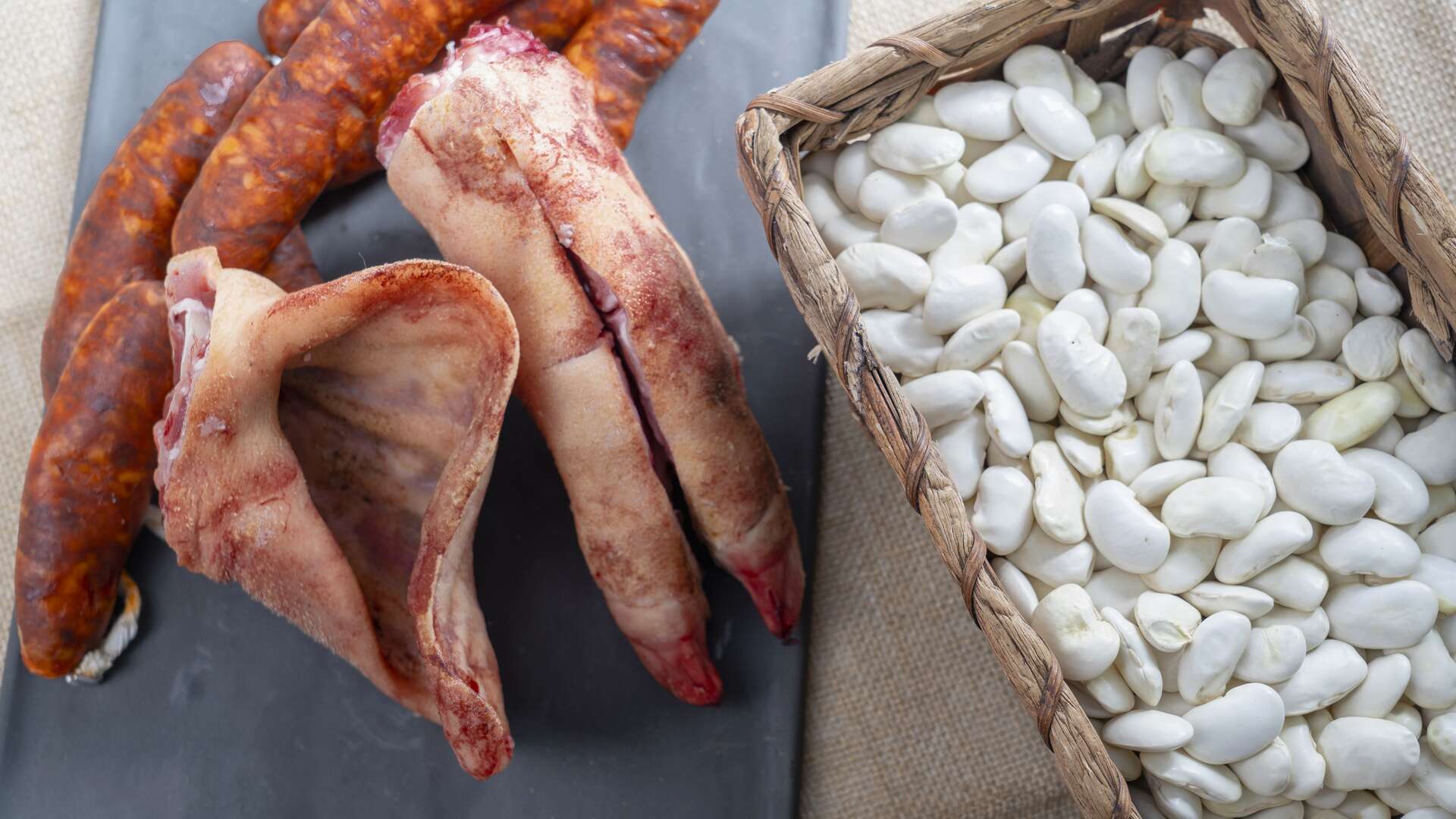 Judiones de La Granja acompañados de chorizo, oreja de cerdo y otros productos tradicionales empleados en el guiso. | Dreamstime