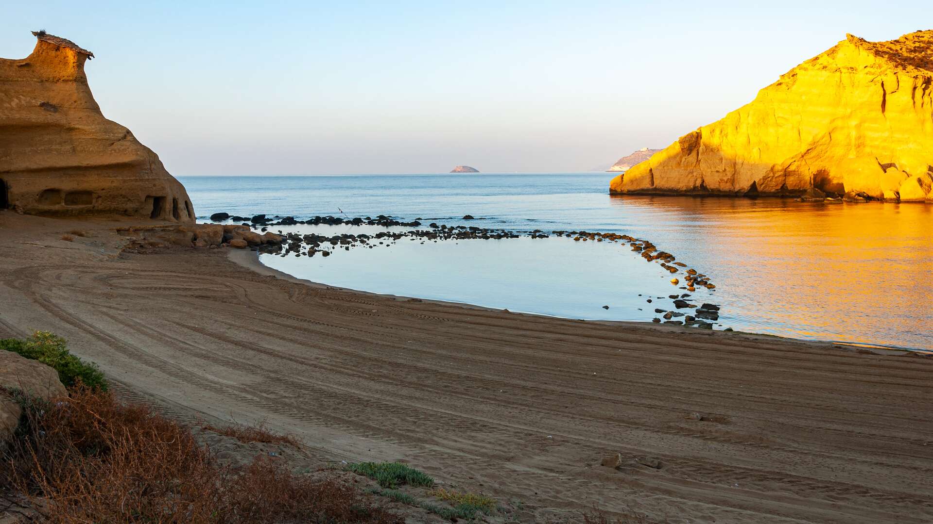 La cala de los Cocedores, entre acantilados dorados y aguas tranquilas. | Dreamstime